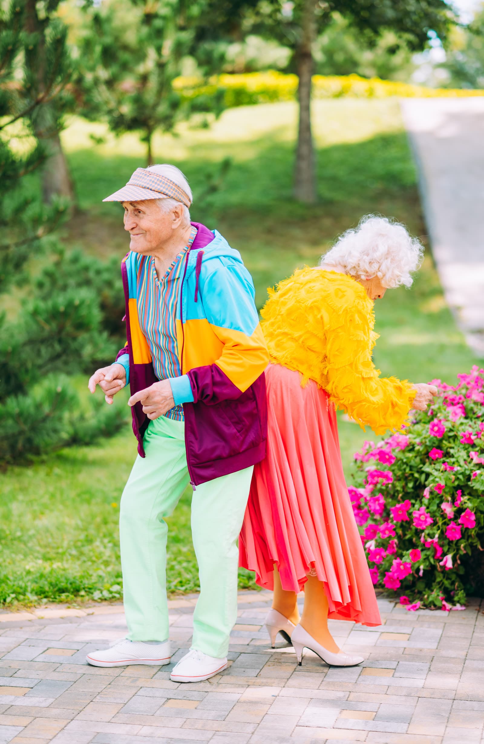 Couple de personnes âgées profitant d'une promenade dans un parc fleuri